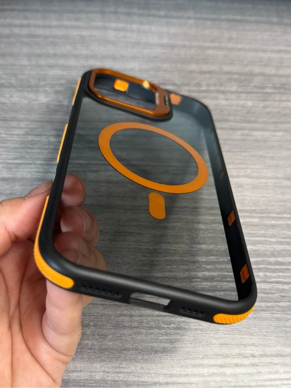 Transparent iPhone 16 Pro Max case, orange and black, MagSafe compatible.